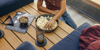 Child eating popcorn on their Neighbor teak outdoor in-line table.