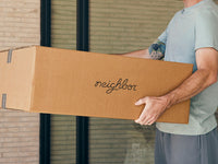 A stack of Neighbor boxes waiting to be unpacked on a sunny doorstep