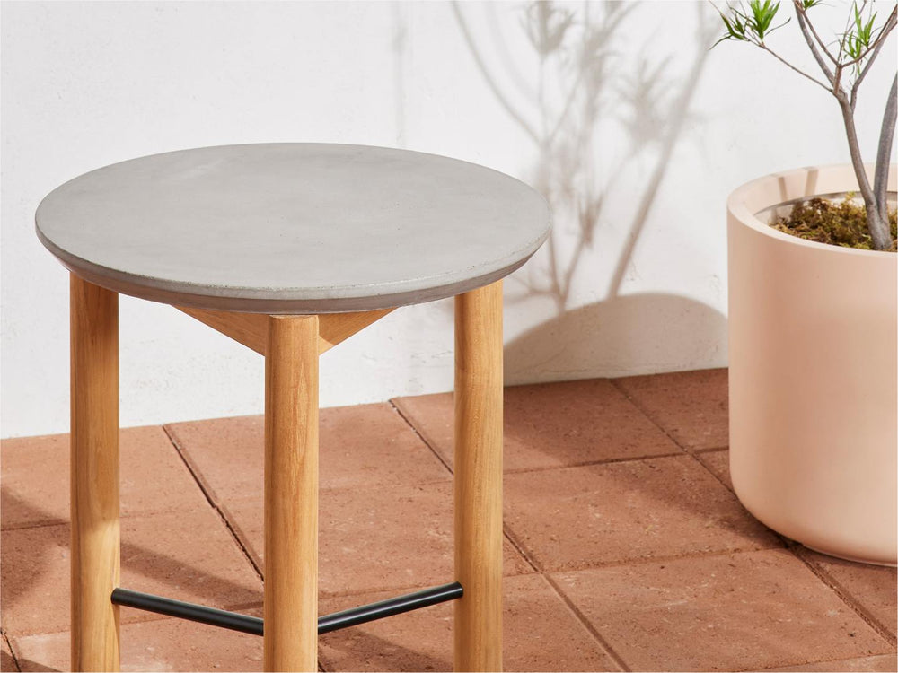 A Neighbor concrete side table sitting on a sunny patio