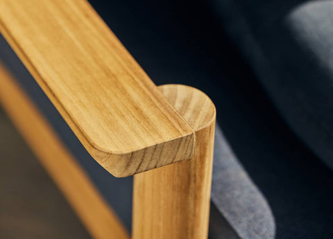 Closeup detail of armrest on teak outdoor chair