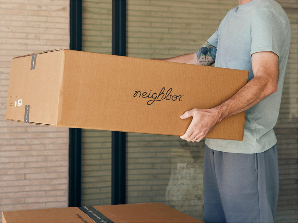 A man carrying a Neighbor box.